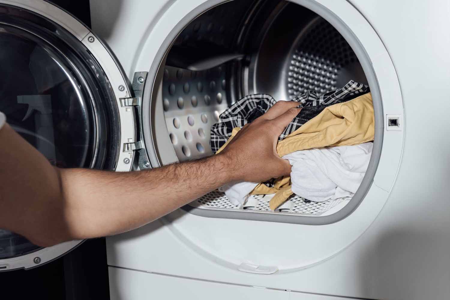 Man washing his clothes once he returned home to kill any bed bugs he brought back from his hotel